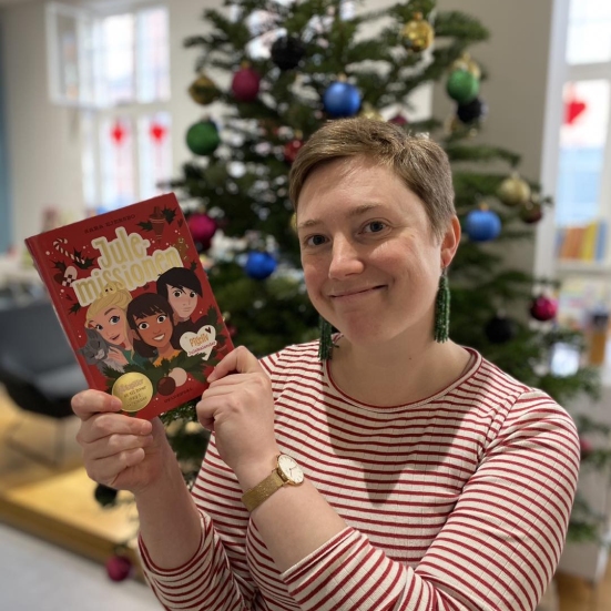 Katrine står med bogen Julemissionen 