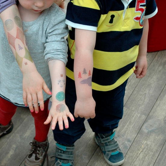 Foto af børnearme med tatoveringer