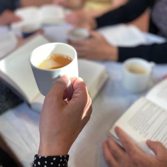 Hænder med kaffe og bøger