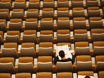 Studerende der sidder og læser i en tom foredragssal